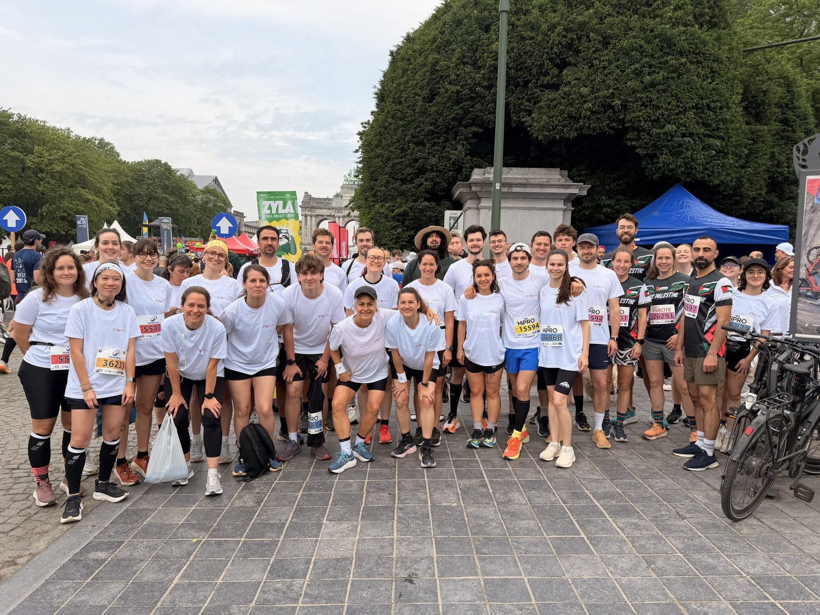Photo de groupe de l'équipe Run4Palestine, dossards épinglés, au parc du Cinquantenaire avant le départ